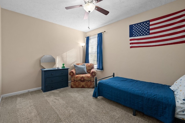 carpeted bedroom with ceiling fan, a textured ceiling, and baseboards