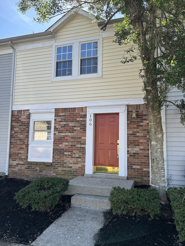 property entrance featuring brick siding