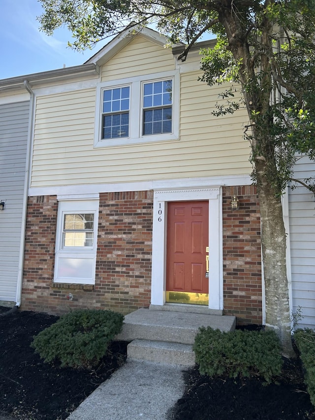 property entrance featuring brick siding