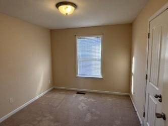 carpeted spare room featuring baseboards