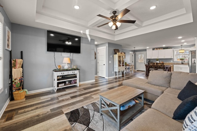 living area featuring recessed lighting, coffered ceiling, baseboards, and wood finished floors