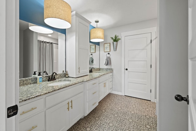 full bathroom featuring double vanity, a sink, and baseboards