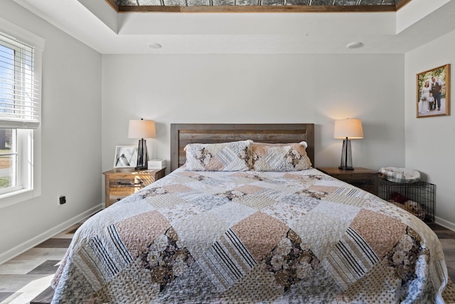 bedroom featuring baseboards and wood finished floors