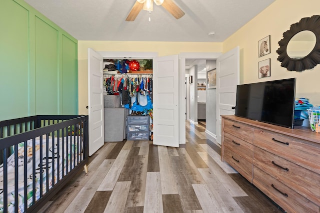 bedroom featuring a closet, wood finished floors, and a ceiling fan