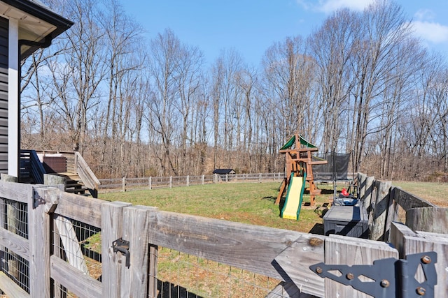 view of yard with a fenced backyard, a trampoline, and a playground