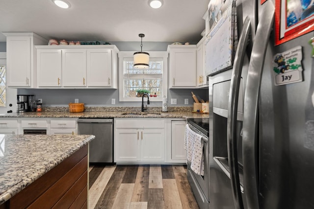 kitchen featuring appliances with stainless steel finishes, a sink, and white cabinets