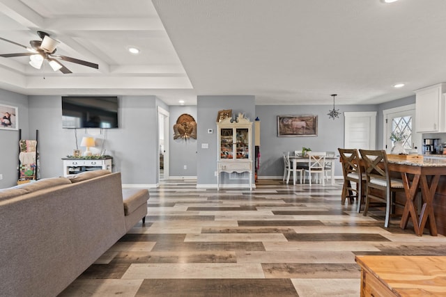 living room featuring ceiling fan, light wood finished floors, recessed lighting, and baseboards