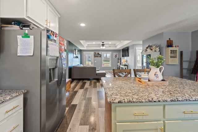 kitchen featuring dark wood-style floors, a center island, a tray ceiling, white cabinetry, and stainless steel fridge