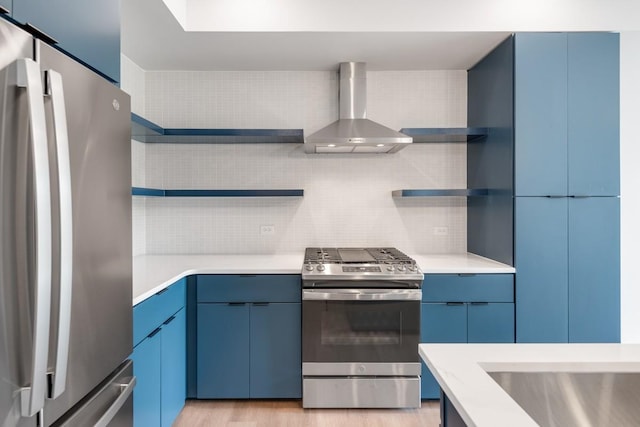 kitchen featuring stainless steel appliances, light countertops, wall chimney exhaust hood, and open shelves