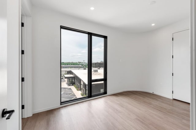 spare room with light wood-style floors, recessed lighting, and baseboards