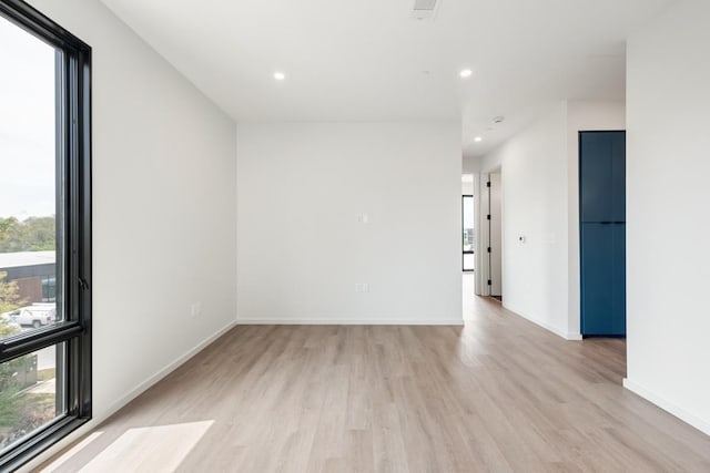 empty room featuring light wood-style flooring, baseboards, and recessed lighting