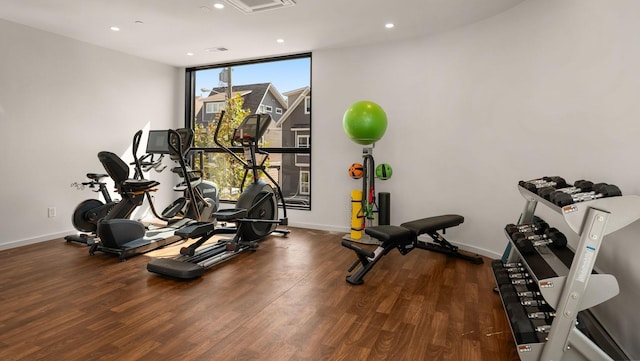 exercise area featuring floor to ceiling windows, baseboards, dark wood-style flooring, and recessed lighting