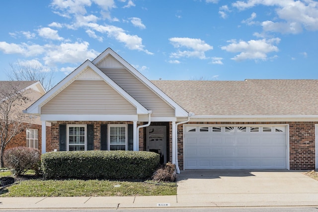 view of front of house featuring a garage, concrete driveway, brick siding, and a shingled roof