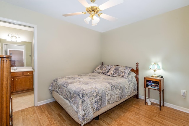 bedroom with light wood-style flooring, connected bathroom, a sink, ceiling fan, and baseboards