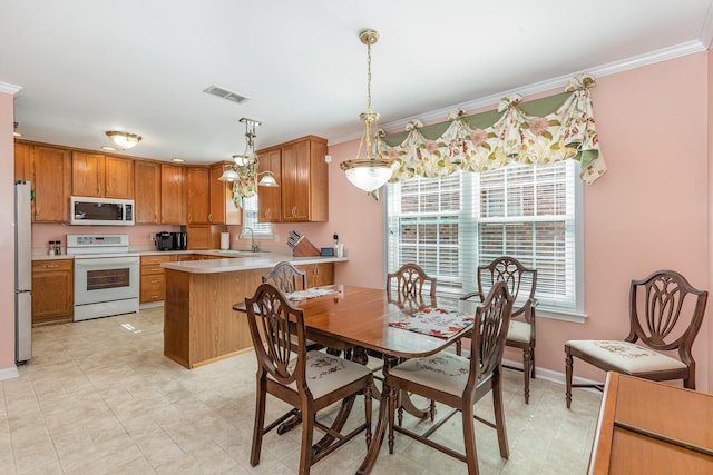 dining area with baseboards, visible vents, and crown molding