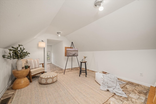 sitting room with lofted ceiling, visible vents, and baseboards