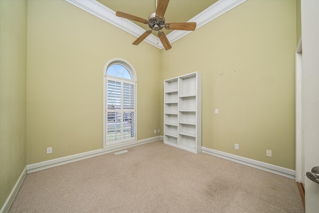 interior space featuring light carpet, visible vents, a ceiling fan, baseboards, and ornamental molding