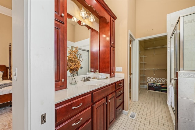 full bathroom featuring a stall shower, tile patterned flooring, a spacious closet, and vanity