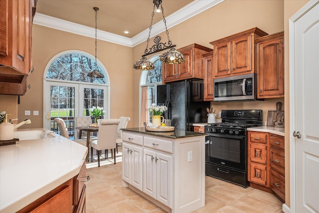 kitchen with brown cabinets, decorative light fixtures, crown molding, black appliances, and a sink