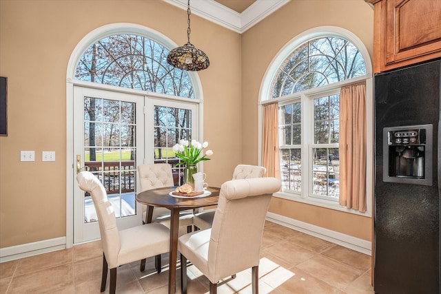 dining room with a healthy amount of sunlight, light tile patterned flooring, and crown molding