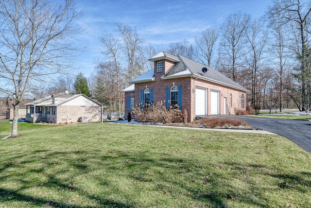 view of home's exterior featuring roof with shingles, brick siding, a lawn, an attached garage, and driveway