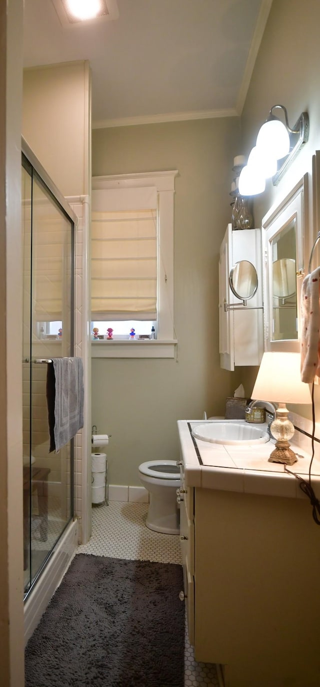 full bath featuring toilet, vanity, baseboards, a shower stall, and crown molding