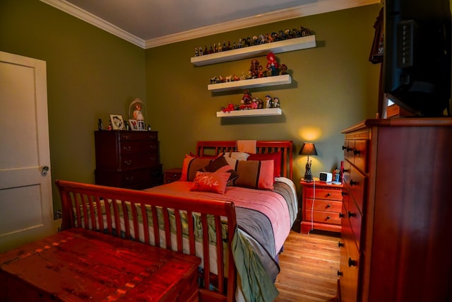 bedroom with crown molding and light wood-style flooring