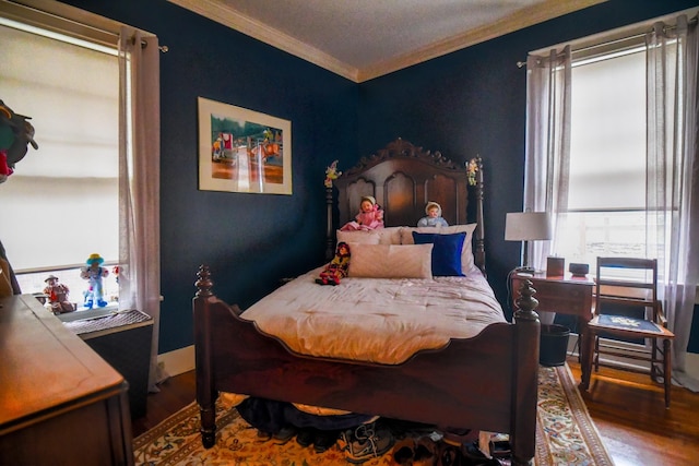 bedroom with ornamental molding and wood finished floors