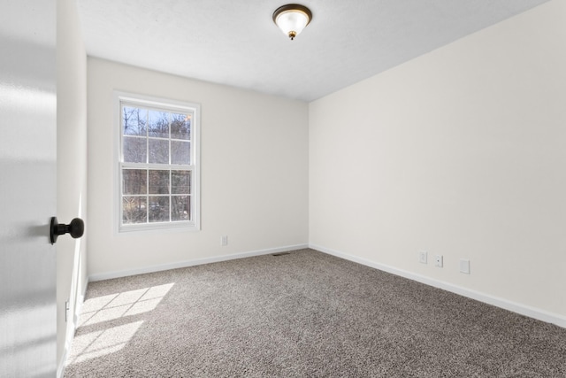 empty room featuring light carpet and baseboards