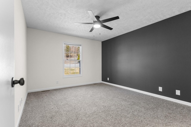 unfurnished room featuring a ceiling fan, carpet, a textured ceiling, and baseboards