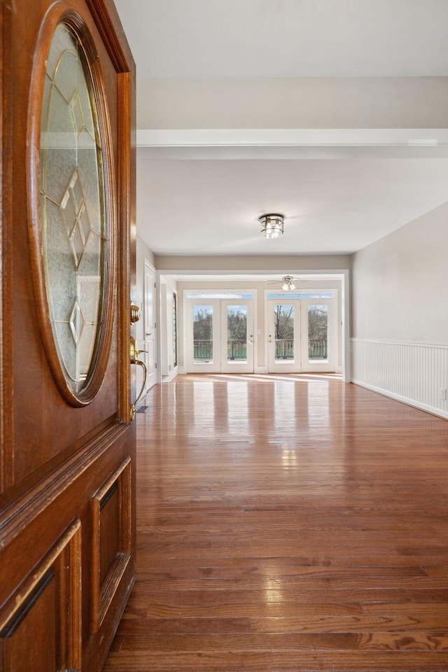 interior space with french doors, wainscoting, and wood finished floors