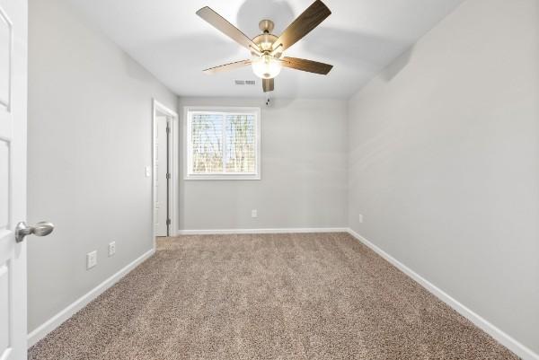 unfurnished room with baseboards, visible vents, ceiling fan, and light colored carpet