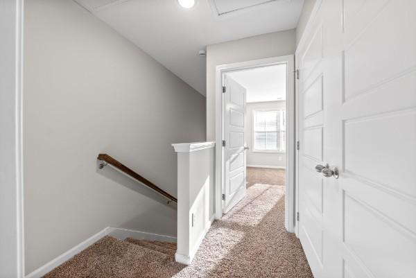 interior space with baseboards, an upstairs landing, and light colored carpet