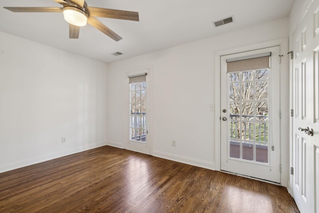 interior space with a healthy amount of sunlight, dark wood-style floors, baseboards, and visible vents