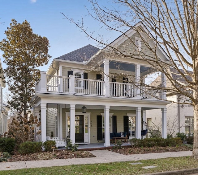 view of front of house with a shingled roof, covered porch, and a balcony