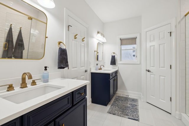 bathroom featuring baseboards, visible vents, two vanities, and a sink