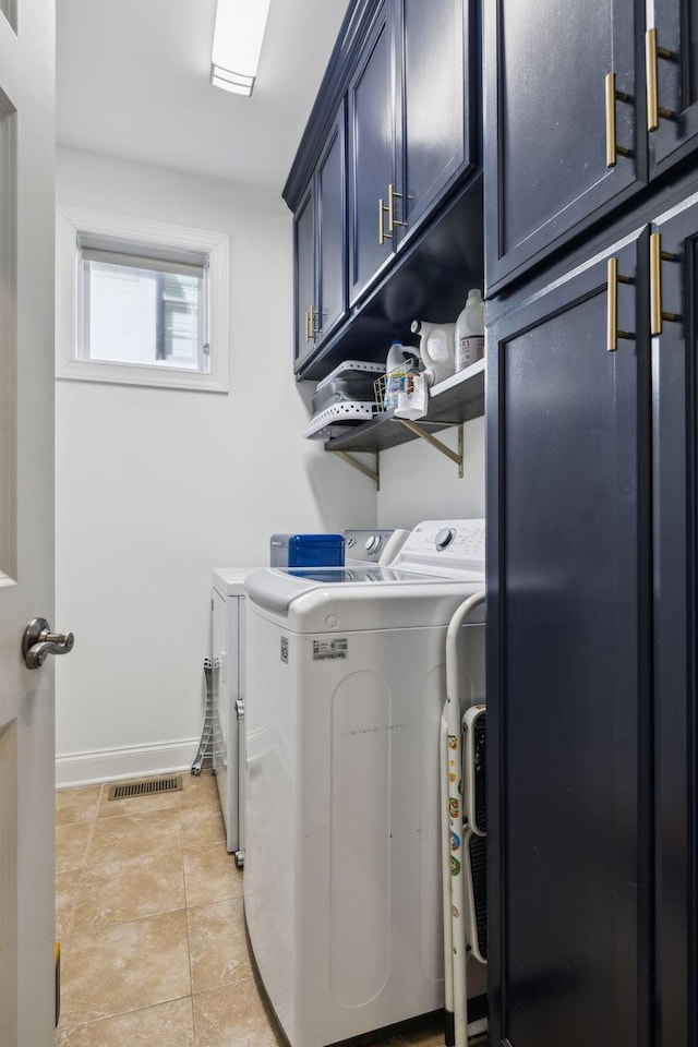 laundry area with cabinet space, visible vents, baseboards, washer and clothes dryer, and light tile patterned flooring