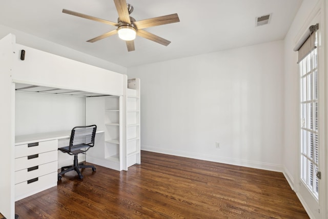 unfurnished office featuring dark wood-style floors, a ceiling fan, visible vents, and baseboards