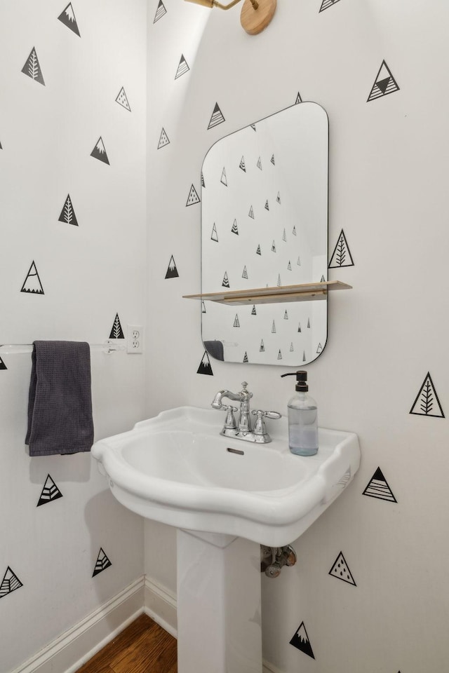 bathroom with a sink, baseboards, and wood finished floors