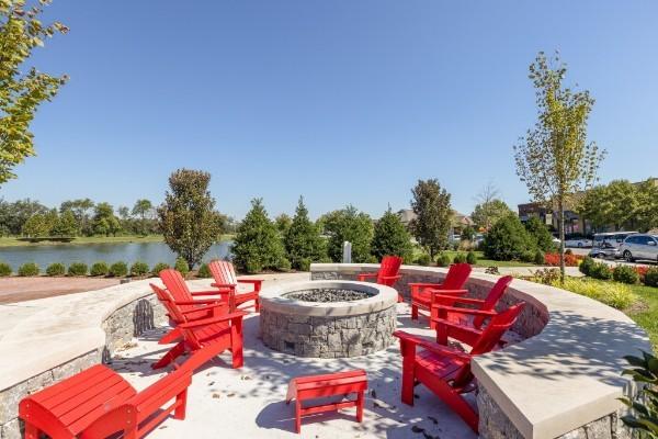 view of patio / terrace featuring an outdoor fire pit and a water view