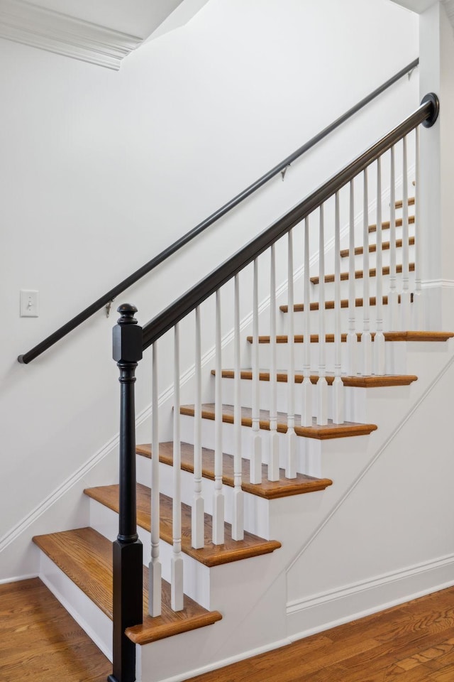 stairway featuring wood finished floors and baseboards