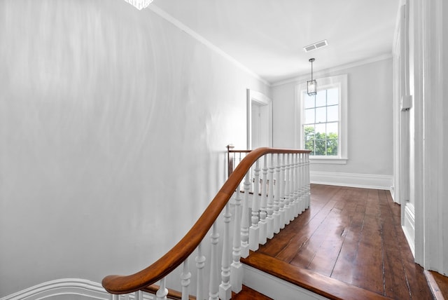 staircase with baseboards, visible vents, wood finished floors, and ornamental molding