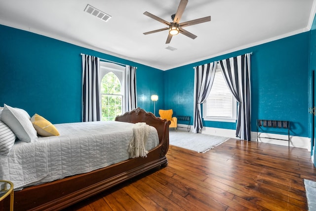 bedroom featuring a ceiling fan, baseboards, visible vents, and wood finished floors