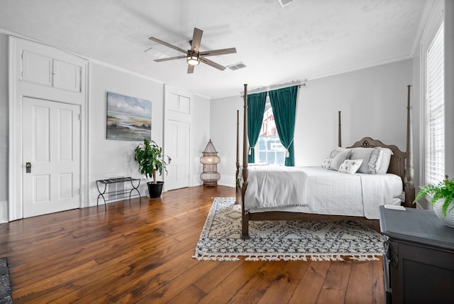 bedroom featuring crown molding, visible vents, dark wood-type flooring, a ceiling fan, and a textured ceiling