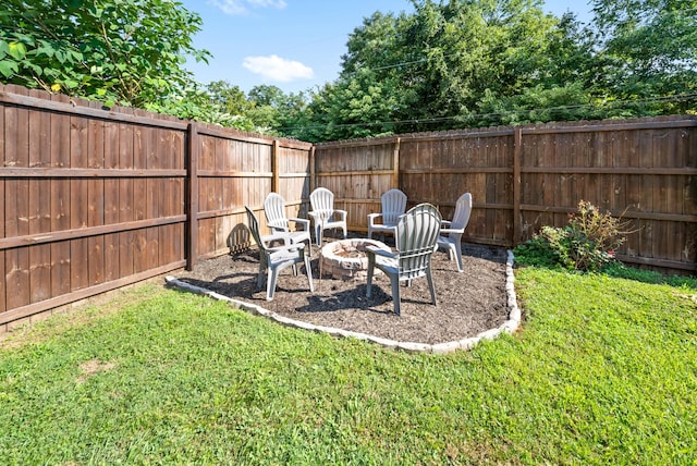 view of yard featuring a fenced backyard and a fire pit