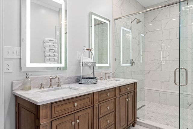 full bathroom with a stall shower, marble finish floor, a sink, and double vanity