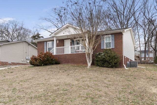 view of front facade featuring a porch, a front yard, brick siding, and central AC unit