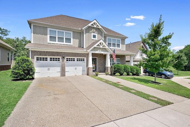 craftsman-style home with driveway, an attached garage, a front lawn, board and batten siding, and brick siding