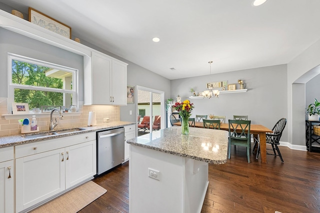 kitchen with a kitchen island, pendant lighting, white cabinets, and stainless steel dishwasher