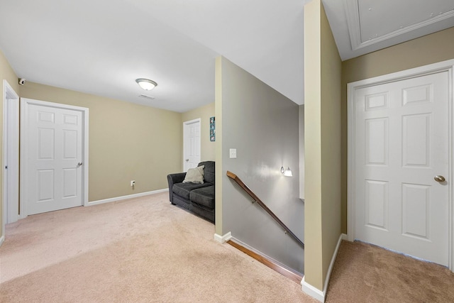 living area with light colored carpet, visible vents, baseboards, an upstairs landing, and attic access